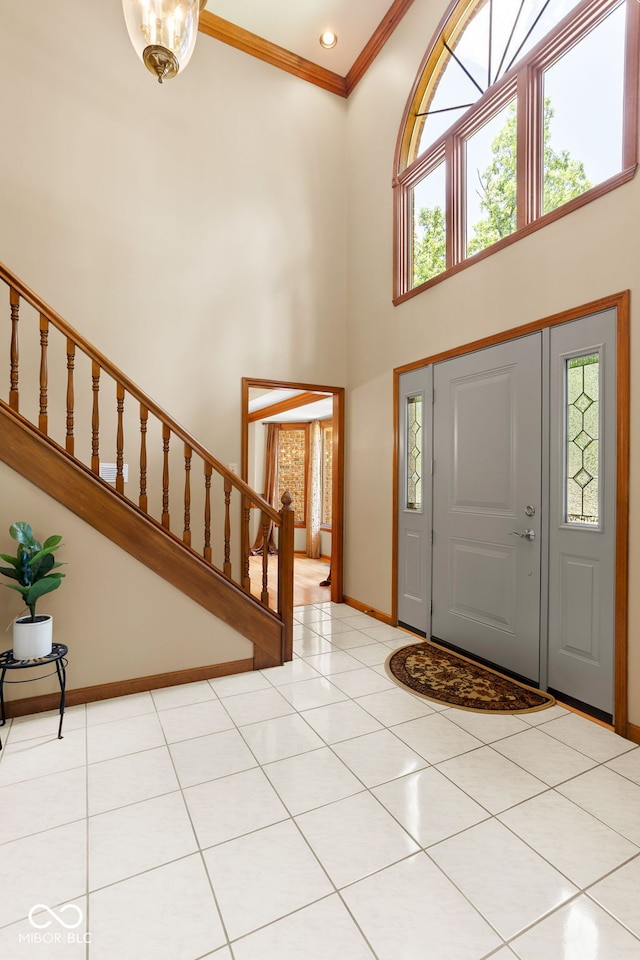 7621 Forest Dr, Fishers, IN 46038 - entrance foyer with a towering ceiling, stairway, ornamental molding, and light tile patterned floors