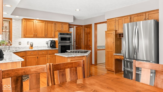 7621 Forest Dr, Fishers, IN 46038 - kitchen with stainless steel appliances, recessed lighting, light wood-style floors, light stone countertops, and brown cabinetry