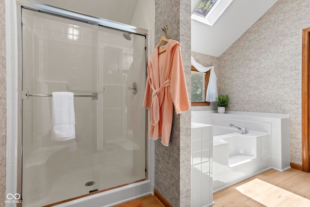 7621 Forest Dr, Fishers, IN 46038 - full bathroom featuring a skylight, lofted ceiling, wood finished floors, a stall shower, and a garden tub