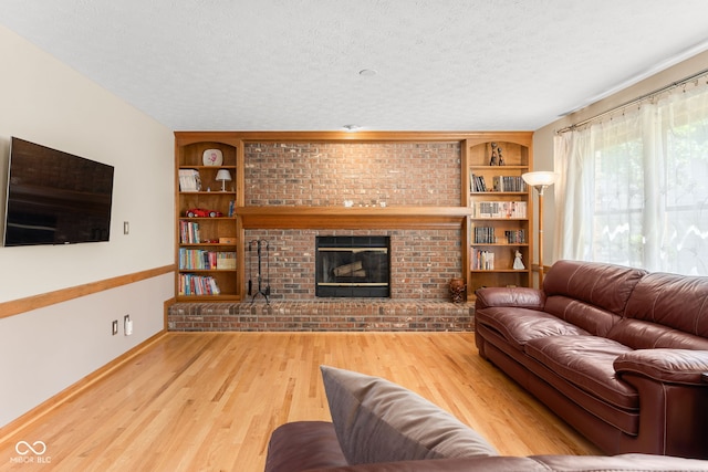 7621 Forest Dr, Fishers, IN 46038 - living room with a textured ceiling, a brick fireplace, wood finished floors, and built in shelves