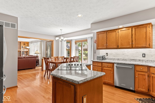 7621 Forest Dr, Fishers, IN 46038 - kitchen featuring stainless steel appliances, brown cabinetry, a chandelier, a textured ceiling, and recessed lighting