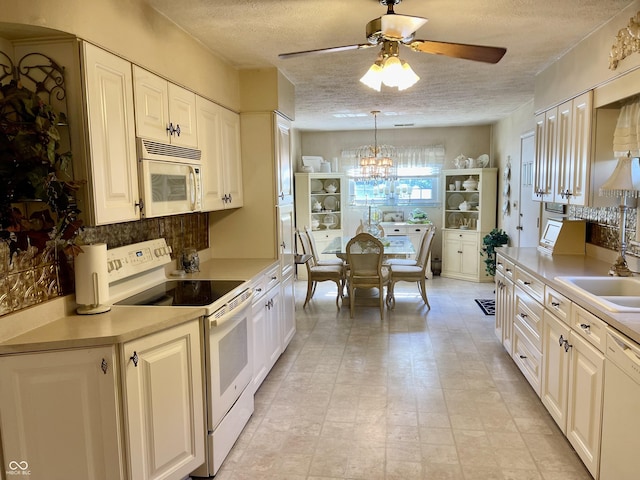 800 Walton Dr, Plainfield, IN 46168 - kitchen with white appliances, a textured ceiling, a ceiling fan, a chandelier, and light countertops