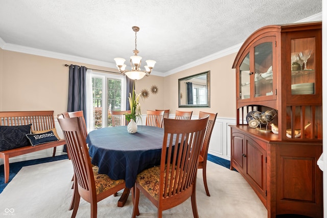 115 Jordan Rd, Indianapolis, IN 46217 - dining space featuring a chandelier, light colored carpet, crown molding, a wainscoted wall, and a textured ceiling