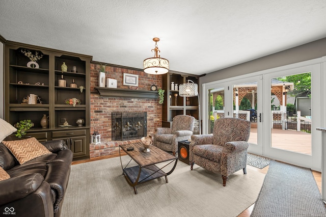 115 Jordan Rd, Indianapolis, IN 46217 - living room with french doors, a fireplace, light wood-style floors, a textured ceiling, and built in shelves
