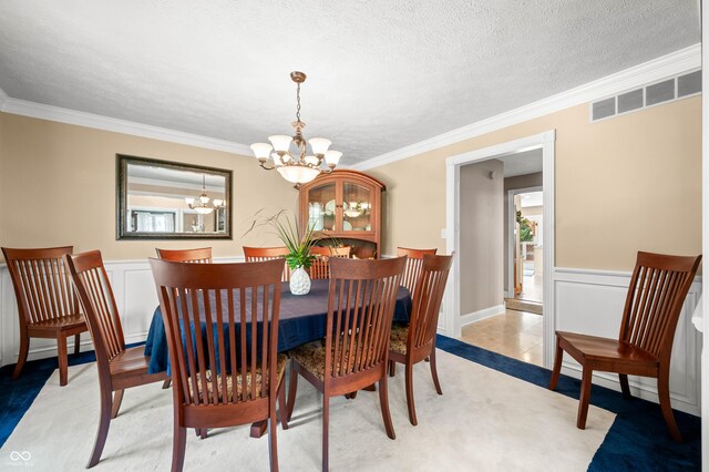 115 Jordan Rd, Indianapolis, IN 46217 - dining room with a chandelier, ornamental molding, a wainscoted wall, light carpet, and a textured ceiling