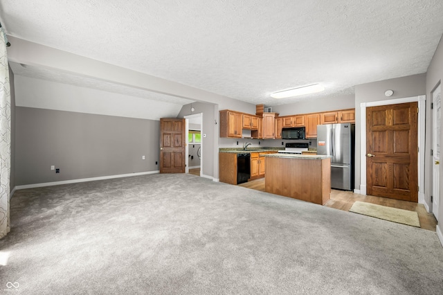 115 Jordan Rd, Indianapolis, IN 46217 - kitchen featuring black appliances, a center island, a textured ceiling, light colored carpet, and light countertops