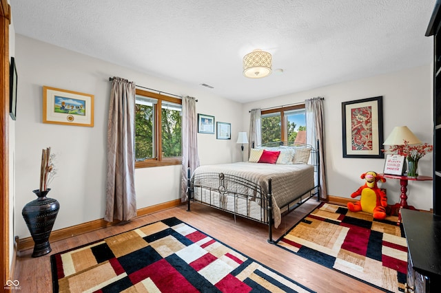 115 Jordan Rd, Indianapolis, IN 46217 - bedroom featuring multiple windows, light wood-style flooring, and a textured ceiling