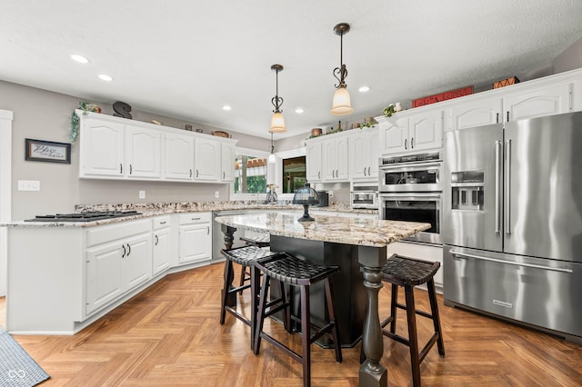 115 Jordan Rd, Indianapolis, IN 46217 - kitchen with appliances with stainless steel finishes, recessed lighting, white cabinets, a center island, and a breakfast bar