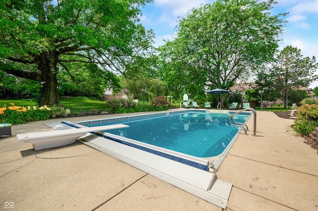 115 Jordan Rd, Indianapolis, IN 46217 - view of swimming pool featuring a diving board, a patio area, and view of wooded area