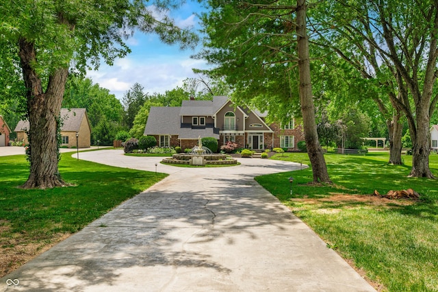 115 Jordan Rd, Indianapolis, IN 46217 - view of front of home featuring a front lawn, brick siding, curved driveway, and a chimney