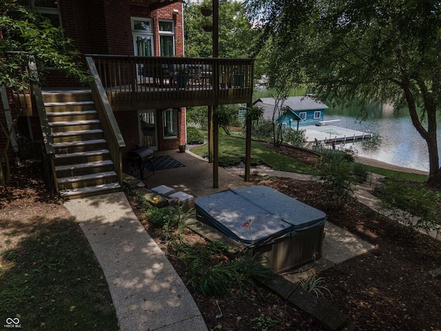 13299 W Wildflower Dr, Columbus, IN 47201 - view of yard with stairs, a hot tub, a patio, and a deck with water view