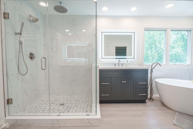 13299 W Wildflower Dr, Columbus, IN 47201 - bathroom with a marble finish shower, a freestanding tub, vanity, wood finished floors, and recessed lighting