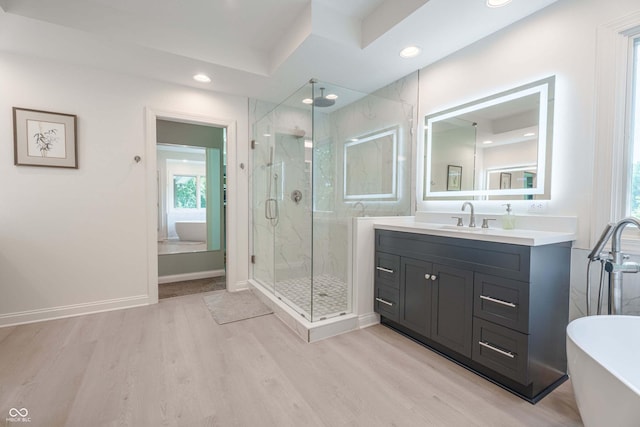 13299 W Wildflower Dr, Columbus, IN 47201 - full bathroom featuring a soaking tub, a marble finish shower, wood finished floors, vanity, and healthy amount of natural light