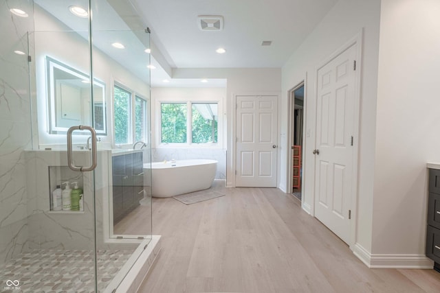 13299 W Wildflower Dr, Columbus, IN 47201 - full bathroom featuring wood finished floors, a soaking tub, a marble finish shower, vanity, and recessed lighting