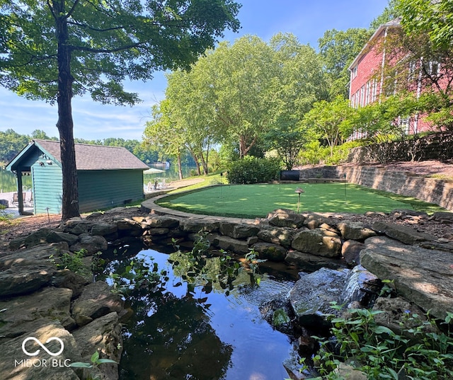 13299 W Wildflower Dr, Columbus, IN 47201 - view of yard with a putting green and a garden pond