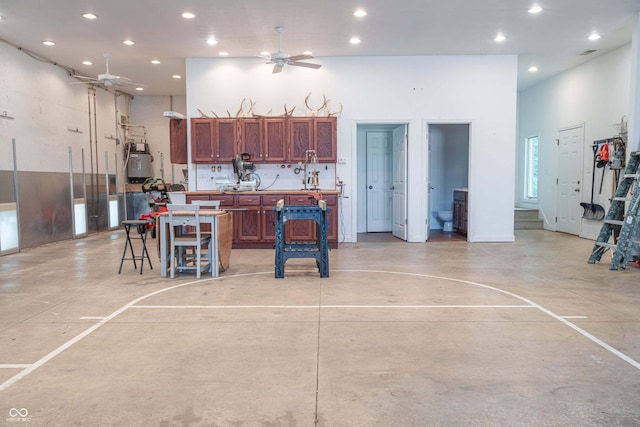 13299 W Wildflower Dr, Columbus, IN 47201 - kitchen with ceiling fan, recessed lighting, finished concrete flooring, a breakfast bar, and a high ceiling