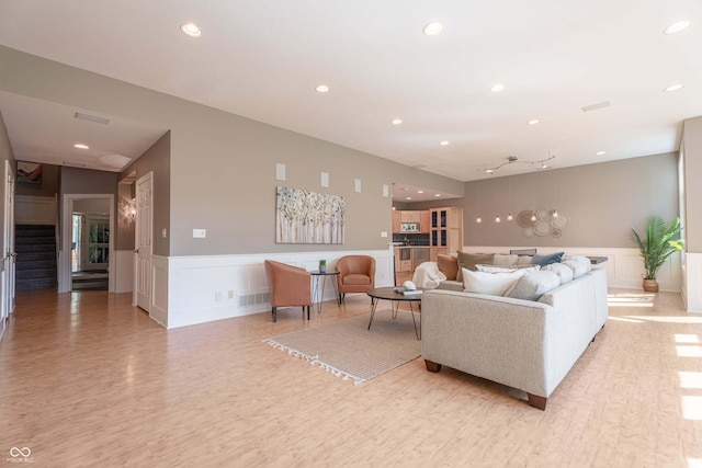 13299 W Wildflower Dr, Columbus, IN 47201 - living room with a decorative wall, a wainscoted wall, recessed lighting, and light wood-type flooring