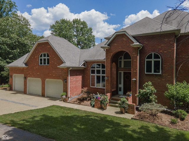 13299 W Wildflower Dr, Columbus, IN 47201 - traditional-style home featuring roof with shingles, brick siding, a garage, and concrete driveway