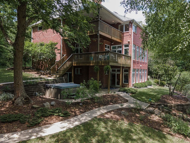13299 W Wildflower Dr, Columbus, IN 47201 - back of house featuring a hot tub, brick siding, a balcony, a lawn, and a deck