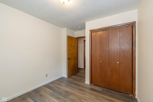 4823 Tempe Ct, Indianapolis, IN 46241 - unfurnished bedroom with wood finished floors, a closet, and a textured ceiling