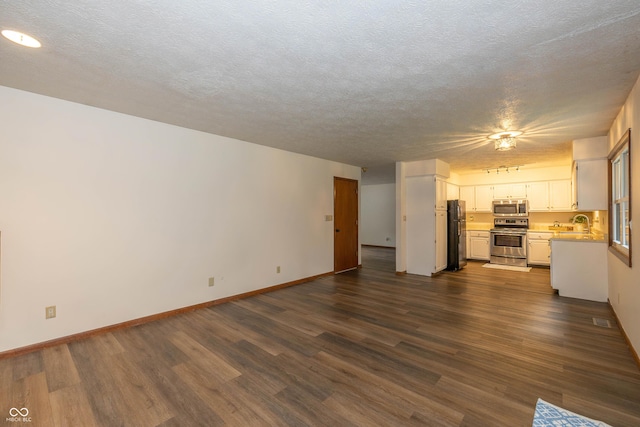4823 Tempe Ct, Indianapolis, IN 46241 - unfurnished living room with dark wood-style floors and a textured ceiling