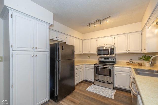 4823 Tempe Ct, Indianapolis, IN 46241 - kitchen featuring stainless steel appliances, light countertops, dark wood finished floors, and white cabinetry