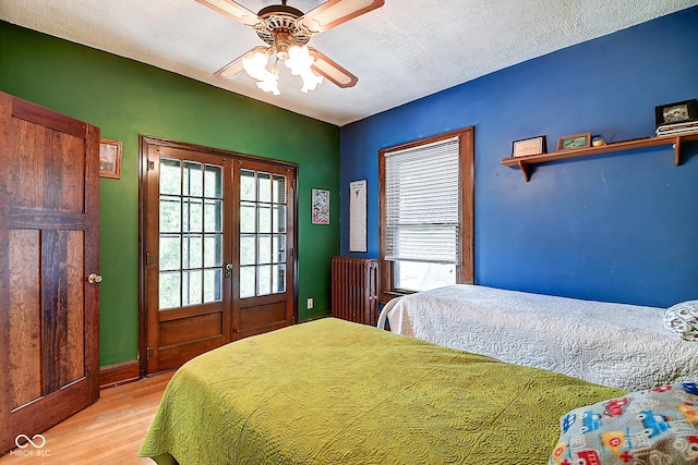 1934 N New Jersey St, Indianapolis, IN 46202 - bedroom featuring light wood-style flooring, french doors, multiple windows, and radiator