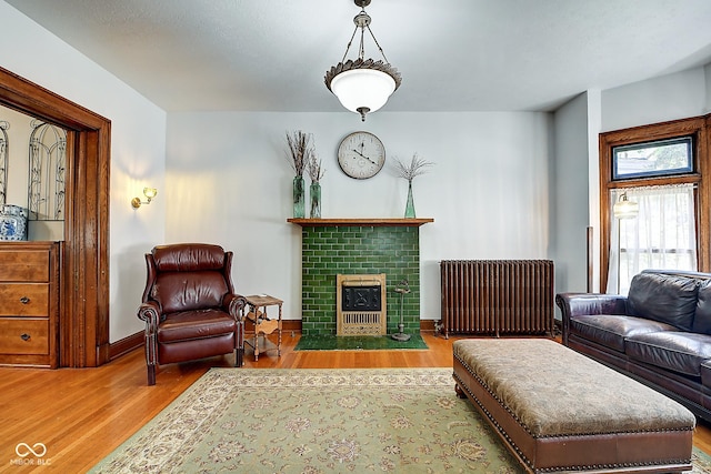 1934 N New Jersey St, Indianapolis, IN 46202 - living room featuring radiator, wood finished floors, and a brick fireplace