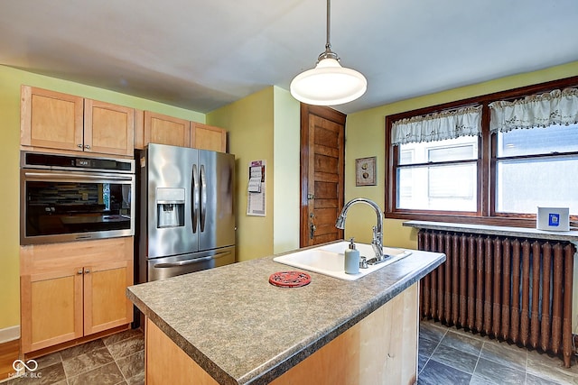 1934 N New Jersey St, Indianapolis, IN 46202 - kitchen with appliances with stainless steel finishes, radiator, light brown cabinets, a kitchen island with sink, and hanging light fixtures