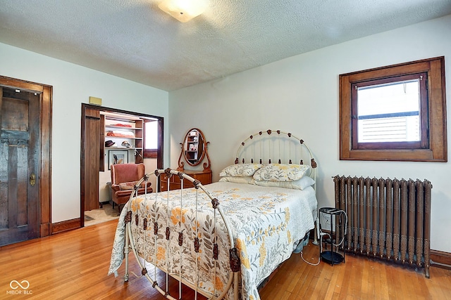 1934 N New Jersey St, Indianapolis, IN 46202 - bedroom with radiator heating unit, hardwood / wood-style floors, and a textured ceiling