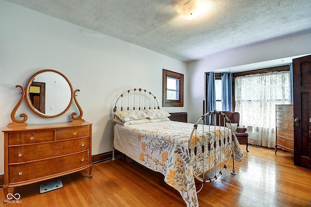 1934 N New Jersey St, Indianapolis, IN 46202 - bedroom with radiator, a textured ceiling, hardwood / wood-style flooring, and multiple windows