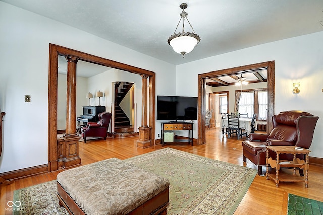 1934 N New Jersey St, Indianapolis, IN 46202 - living room featuring wood finished floors, stairway, ornate columns, and a ceiling fan