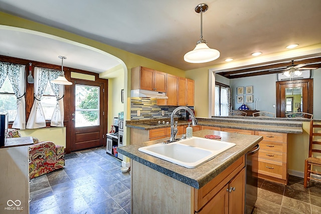 1934 N New Jersey St, Indianapolis, IN 46202 - kitchen featuring under cabinet range hood, an island with sink, dark countertops, arched walkways, and stainless steel dishwasher