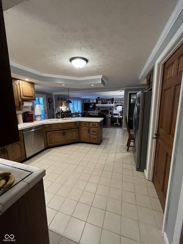 10308 Stormhaven Way, Indianapolis, IN 46256 - kitchen with stainless steel appliances, a tray ceiling, a textured ceiling, ornamental molding, and light tile patterned floors