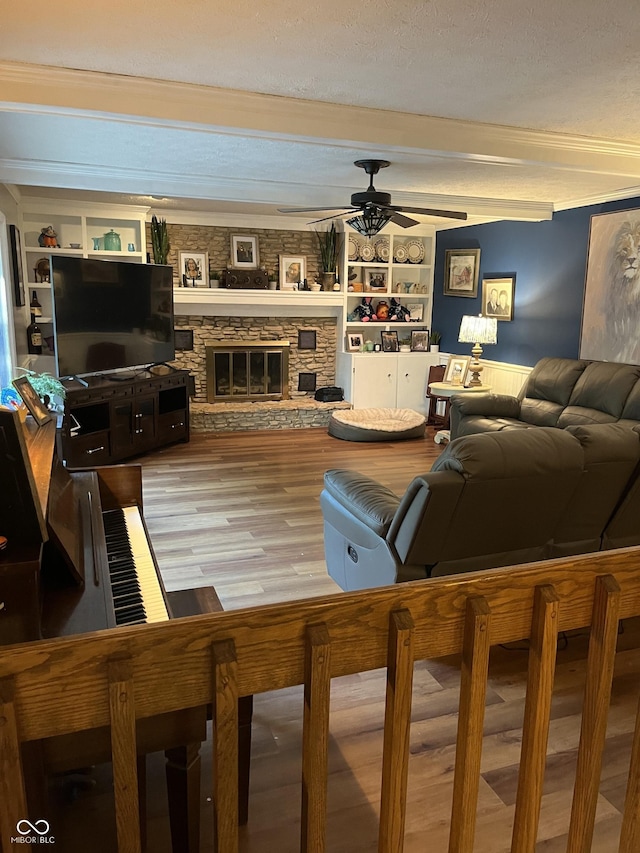 10308 Stormhaven Way, Indianapolis, IN 46256 - living room featuring ceiling fan, wood finished floors, beam ceiling, a stone fireplace, and a textured ceiling