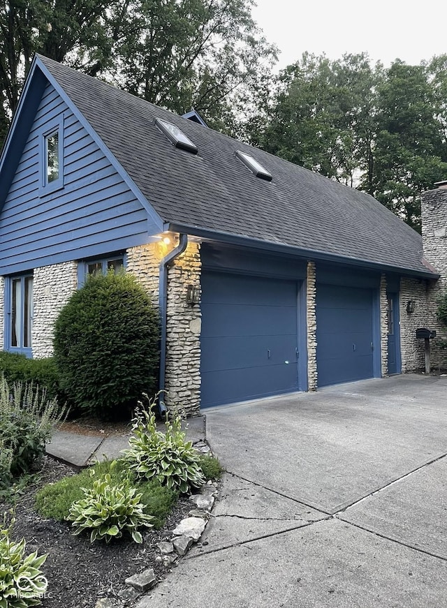 10308 Stormhaven Way, Indianapolis, IN 46256 - view of side of home featuring stone siding, a shingled roof, concrete driveway, and an attached garage