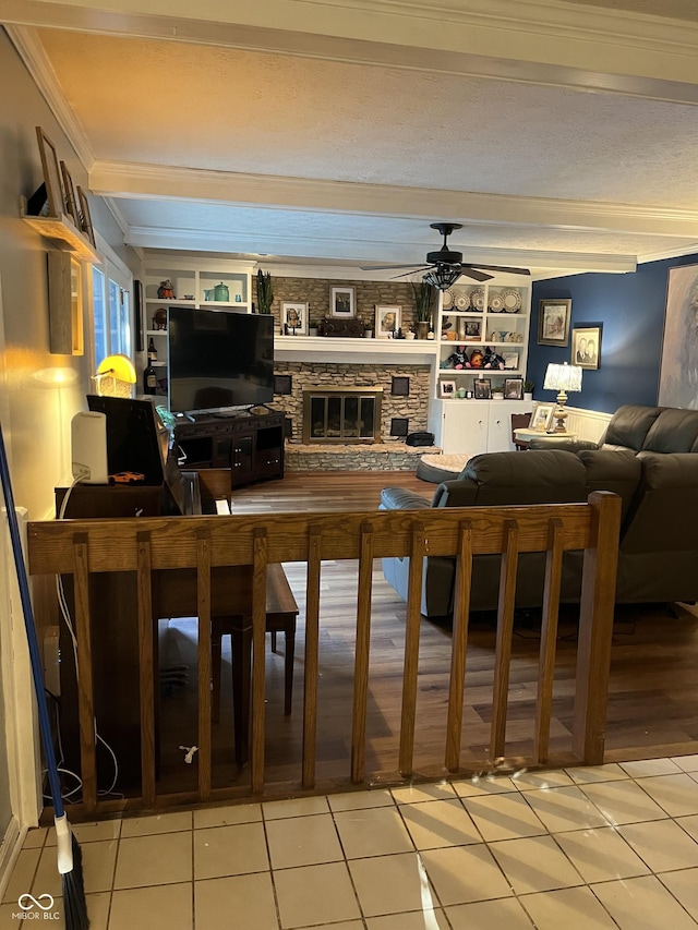10308 Stormhaven Way, Indianapolis, IN 46256 - living area featuring ornamental molding, ceiling fan, a stone fireplace, and light tile patterned floors