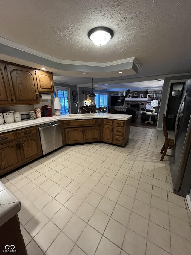 10308 Stormhaven Way, Indianapolis, IN 46256 - kitchen with stainless steel dishwasher, a tray ceiling, a textured ceiling, light countertops, and a peninsula