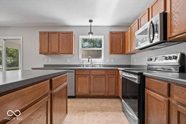 13386 Smokey Quartz Ln, Fishers, IN 46038 - kitchen with appliances with stainless steel finishes, dark countertops, and brown cabinetry