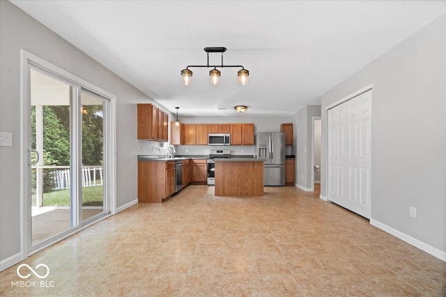 13386 Smokey Quartz Ln, Fishers, IN 46038 - kitchen featuring appliances with stainless steel finishes, plenty of natural light, brown cabinets, and decorative light fixtures