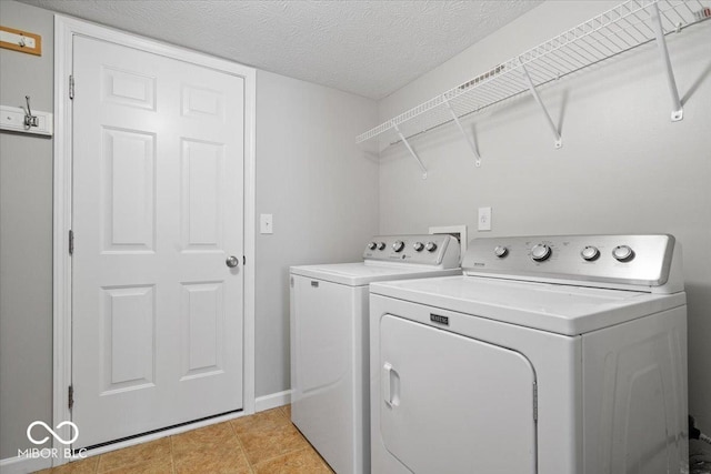 13386 Smokey Quartz Ln, Fishers, IN 46038 - laundry room featuring washing machine and clothes dryer, a textured ceiling, and light tile patterned floors