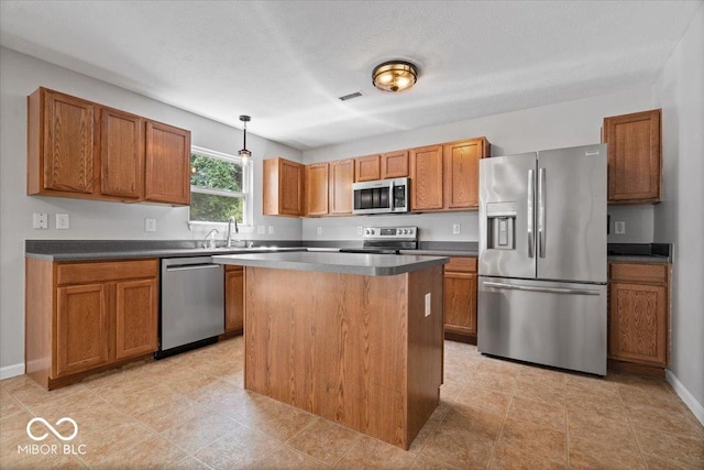 13386 Smokey Quartz Ln, Fishers, IN 46038 - kitchen with appliances with stainless steel finishes, brown cabinets, pendant lighting, and a kitchen island