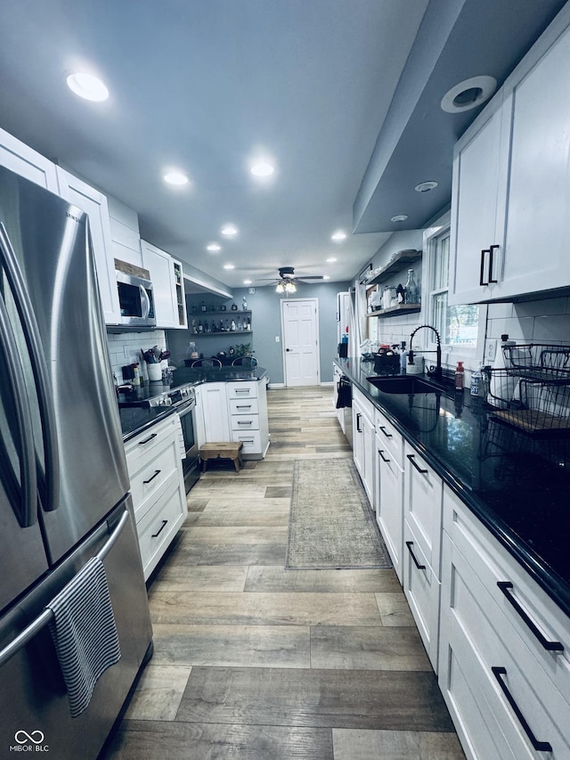 5818 N Fortville Pike, Greenfield, IN 46140 - kitchen featuring stainless steel appliances, open shelves, dark countertops, decorative backsplash, and light wood-type flooring