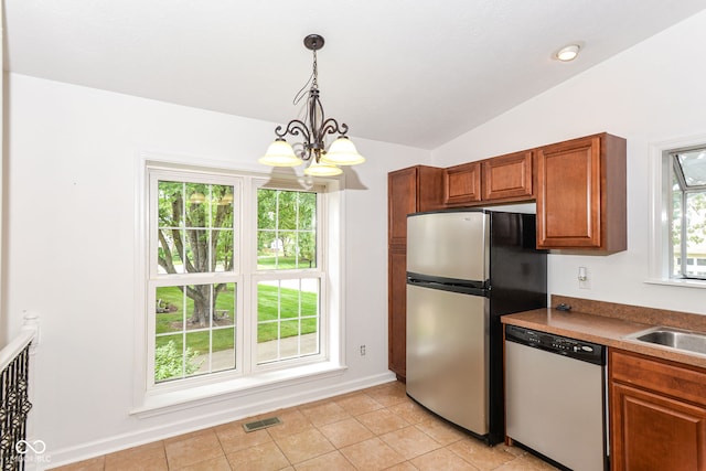7547 Prairie Lake Dr, Indianapolis, IN 46256 - kitchen with appliances with stainless steel finishes, a chandelier, vaulted ceiling, brown cabinets, and pendant lighting