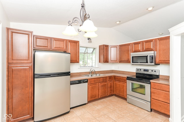 7547 Prairie Lake Dr, Indianapolis, IN 46256 - kitchen with stainless steel appliances, lofted ceiling, light tile patterned floors, pendant lighting, and brown cabinets