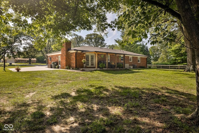 2748 S Meridian Rd, Greenfield, IN 46140 - rear view of property with french doors, concrete driveway, a chimney, brick siding, and an attached garage
