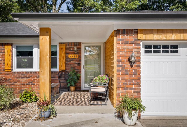 2748 S Meridian Rd, Greenfield, IN 46140 - view of exterior entry featuring brick siding, covered porch, and an attached garage