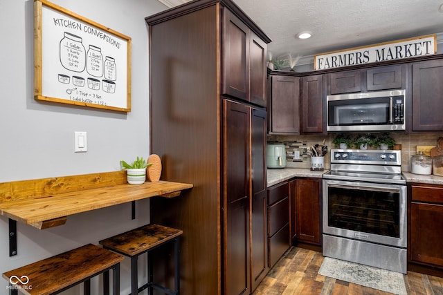 2748 S Meridian Rd, Greenfield, IN 46140 - kitchen featuring appliances with stainless steel finishes, dark brown cabinets, decorative backsplash, wood finished floors, and recessed lighting