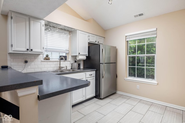 9751 Roxbury Dr, Fishers, IN 46038 - kitchen with freestanding refrigerator, dark countertops, decorative backsplash, healthy amount of natural light, and vaulted ceiling