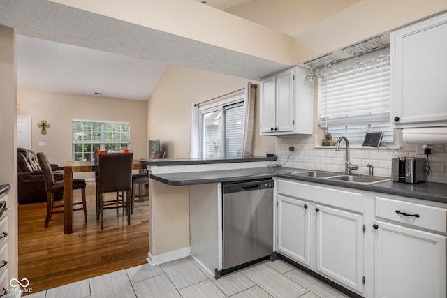 9751 Roxbury Dr, Fishers, IN 46038 - kitchen with dishwasher, dark countertops, white cabinetry, tasteful backsplash, and a peninsula